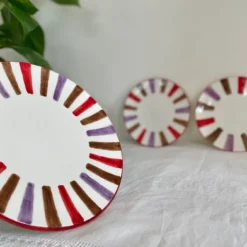 Assiette en céramique multicolore avec détails géométriques, idéale pour la décoration de table.