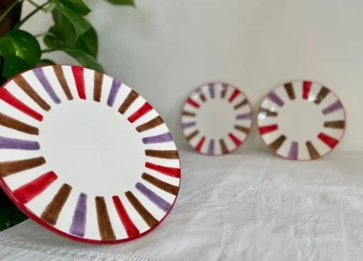 Assiette en céramique multicolore avec détails géométriques, idéale pour la décoration de table.